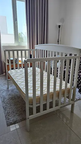 White oval baby crib with mattress — new condition