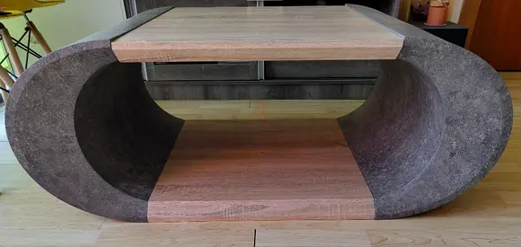 Modern oval coffee table with wood finish and stone-effect sides