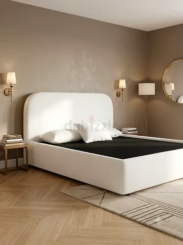 White upholstered double bed frame with curved headboard —