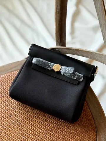 Small black structured shoulder bag with gold clasp