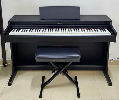 The Yamaha Arius YDP-163B is an 88-key console digital piano in a black walnut finish designed