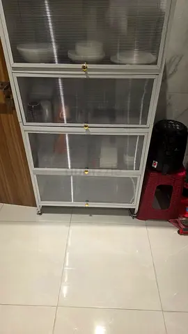 White glass-front kitchen storage cabinet on wheels