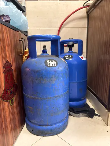 Two blue LPG gas cylinders with regulator and hose- used, good for home use