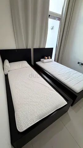 Pair of single wooden beds with mattresses - dark brown