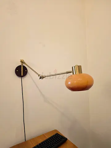 Adjustable wall-mounted reading lamp with peach glass shade