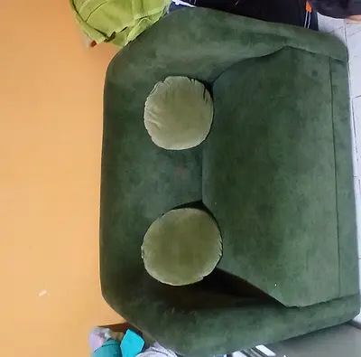 Green velvet single-seater armchair with two round cushions