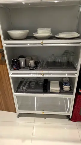 White glass-front kitchen storage cabinet on wheels