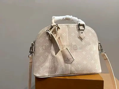 Cream monogrammed designer-style dome handbag with detachable strap