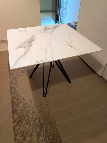 Modern square dining table with marble-effect top and black metal legs