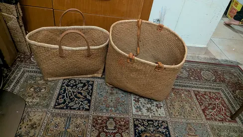Pair of woven seagrass storage baskets with leather handles