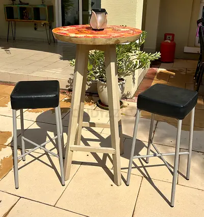 High Pedestal cocktail table + 2 black cushion bar stools