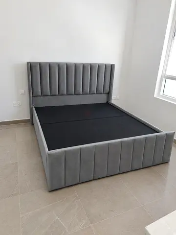 Grey upholstered double bed with padded headboard