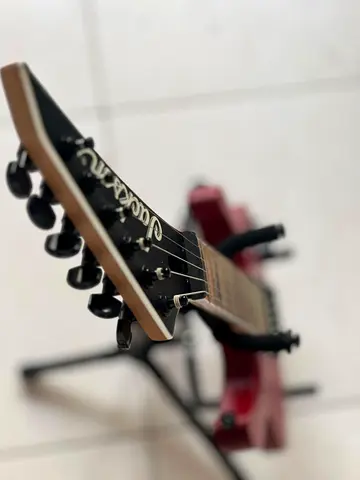 Red electric guitar (Jackson-style) with stand — good condition
