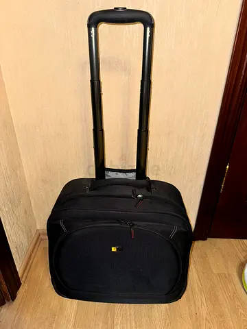 Compact black roller carry-on suitcase with telescopic handle