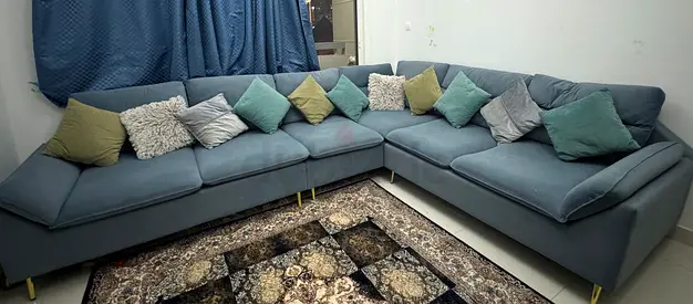 Large L-shaped sectional sofa in blue-grey with cushions - good condition