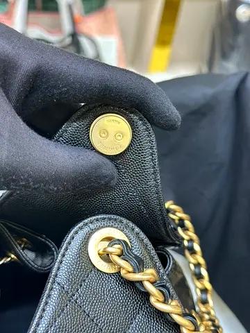 Chanel 25 bag featuring a woven leather and gold-tone chain handle