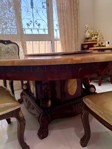Antique-style carved wooden dining table with marble top
