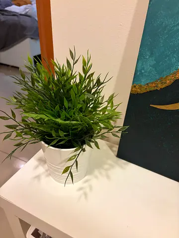 Artificial potted plant in white ribbed pot