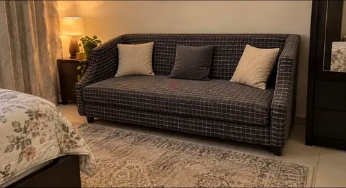 Three-seater grey checkered sofa in good condition