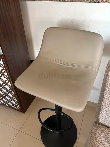 Beige adjustable bar stool with black metal base - good condition