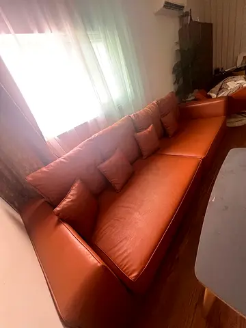Large modern sofa for sale, upholstered in elegant Caramel Brown faux leather and approximately one