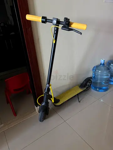 Used electric scooter with yellow grips and deck - good condition