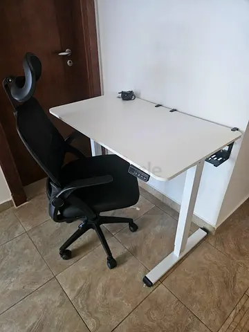 White adjustable standing/sitting desk with black ergonomic office chair