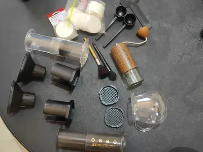 AeroPress coffee maker with accessories (filters, scoops, grinder parts)