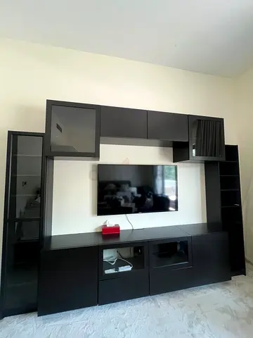 Large dark wood TV entertainment center with cabinets and shelves