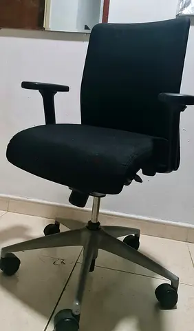 Black ergonomic office chair with armrests and wheels