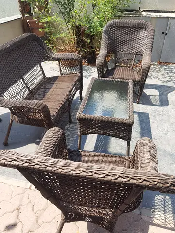 4-piece brown rattan outdoor seating set with glass-top side table with water resistant cushions