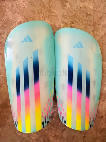 pair of adidas X League Shin Guards (model code HF9744) in the Clear Aqua, Bright Cyan, and Solar Re