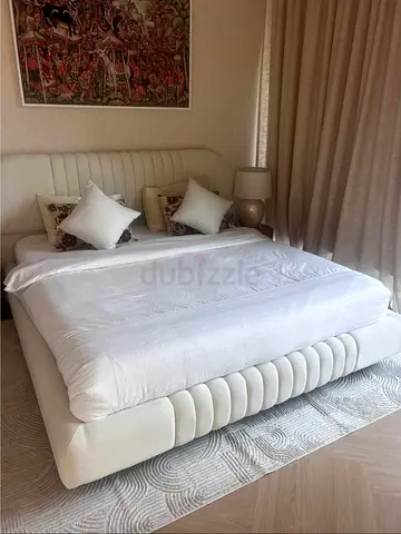 White upholstered king-size bed with padded headboard