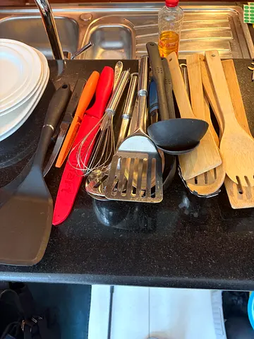Mixed kitchen utensils set — spatulas, ladles, whisks, wooden spoons (used)