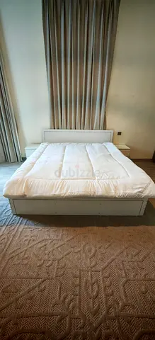 White King size bed frame with a mattress and 2 bedside tables
