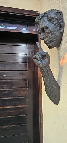 Bronze-style wall-mounted sculpture of a hand and partial bust (decor/art piece)