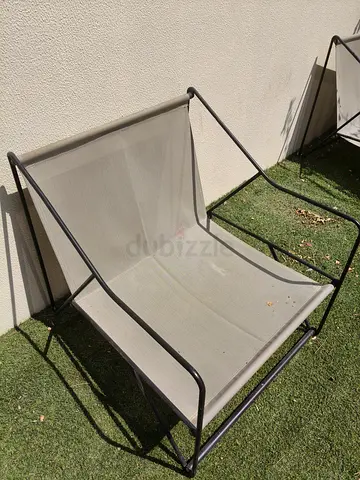 Outdoor metal frame lounge chair with orange cushions
