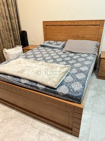 Queen-size bed frame with mattress and bedside cabinets