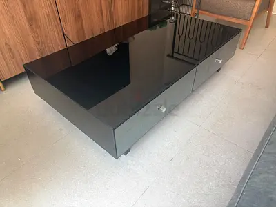 Low black glass coffee table with storage drawers and with real wood on the back