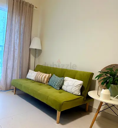 Green fabric sofa bed / futon in good condition