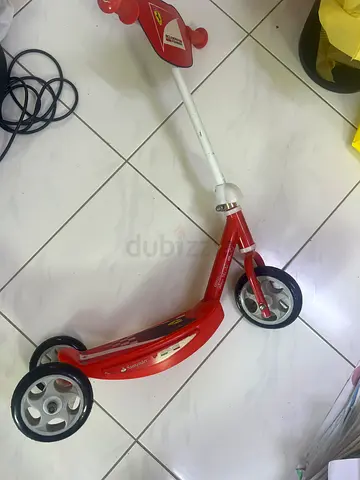 Red three-wheeled kids scooter / ride-on toy in good condition