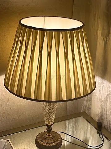 Glass and copper lamp that emits a warm yellow light