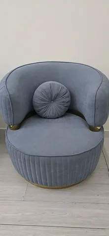 Round grey upholstered accent chair with matching ottoman