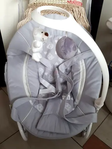 Grey baby rocker/bouncer with toy mobile — good condition