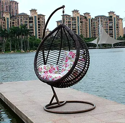Outdoor hanging egg chair with stand and floral cushions