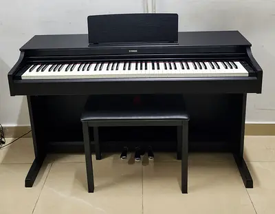 The Yamaha Arius YDP-163B is an 88-key console digital piano in a black walnut finish designed