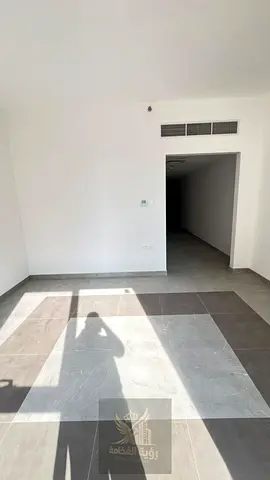 For Rent in Sharjah, New Muwaileh A brand-new one-bedroom apartment with a living room, first occupancy, featuring a balcony and one bathroom. The
