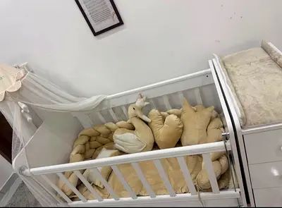White wooden baby bed /crib with attached changer and bedding - good new condition.