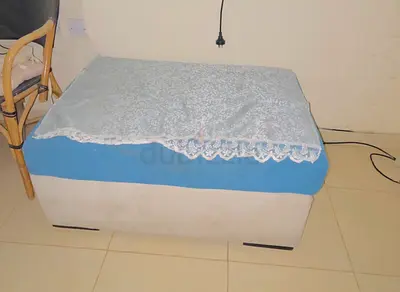 Small upholstered storage ottoman/bench in beige with blue cover