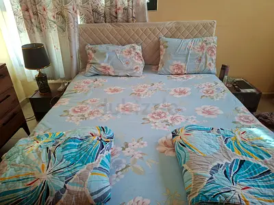 Queen bed with padded headboard and floral bedding - good condition